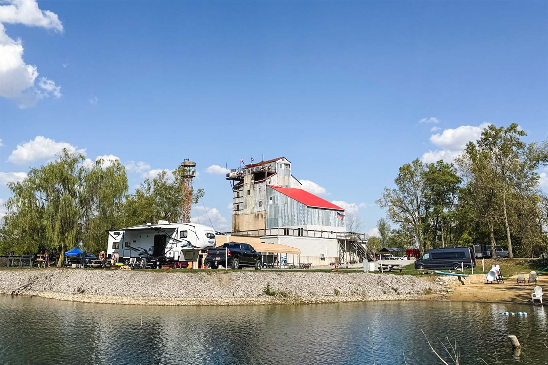 Waterfront RV camping sites at Gilboa Quarry with historic limestone processing building and clear quarry water northwest Ohio
