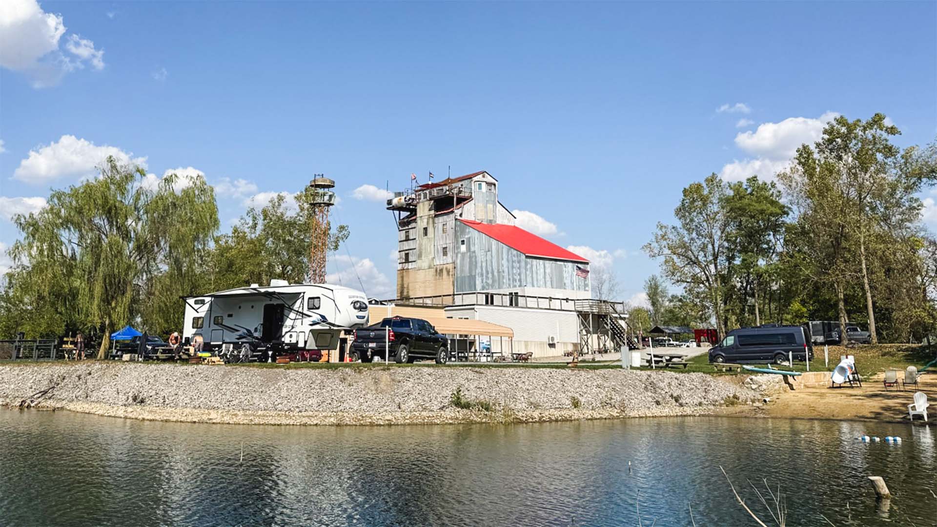 Waterfront RV camping sites at Gilboa Quarry with historic limestone processing building and clear quarry water northwest Ohio